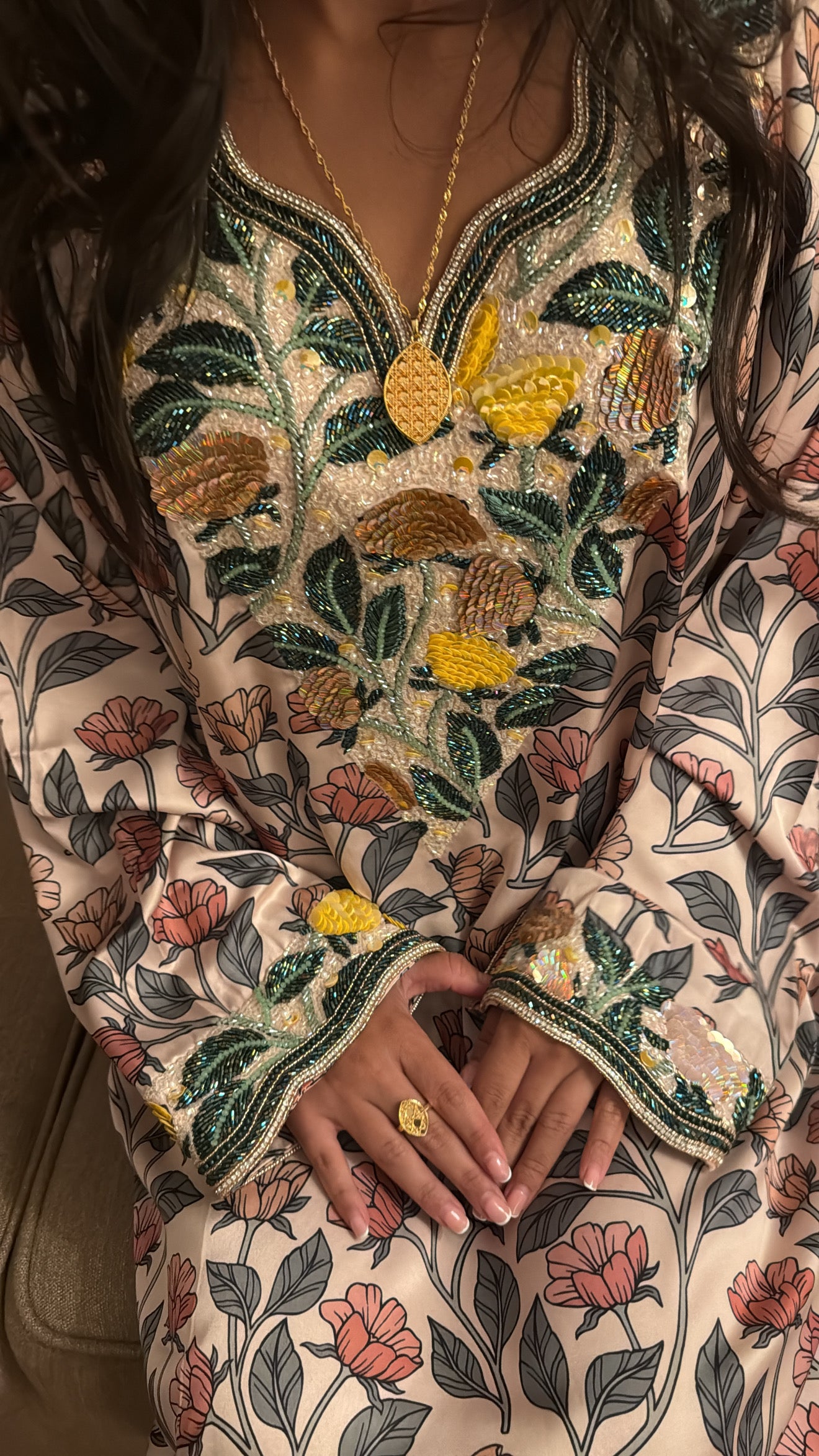 Détail de la broderie main perlée émeraude et dorée du col en V de la Makhaweer ivoire en soie italienne
