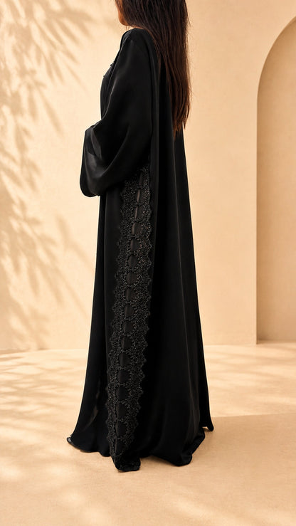 Dos de l'abaya Meraas noire avec sa bande verticale de guipure perlée
