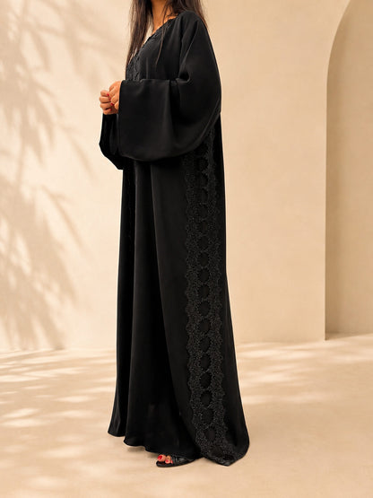 Détail de la dentelle guipure perlée cousue main sur l'abaya Meraas