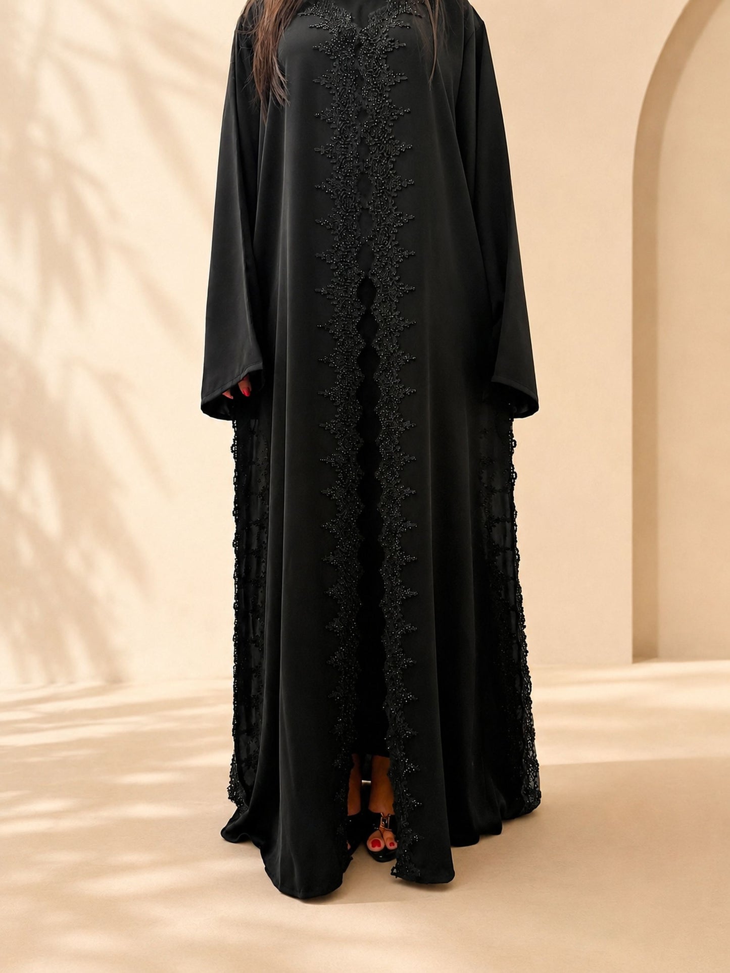Profil de l'abaya Meraas noire, bande de guipure perlée du buste à l'ourlet