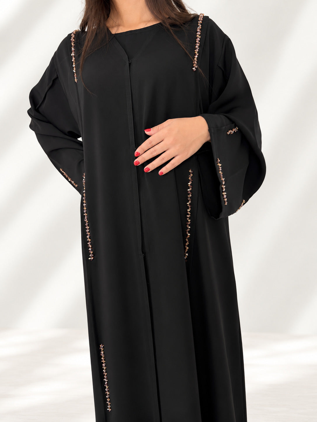 Buste de l'abaya Nimat noire, galons de cristaux dorés le long des coutures