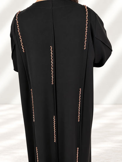 Dos de l'abaya Nimat en gros plan, alignement des cristaux sur les coutures