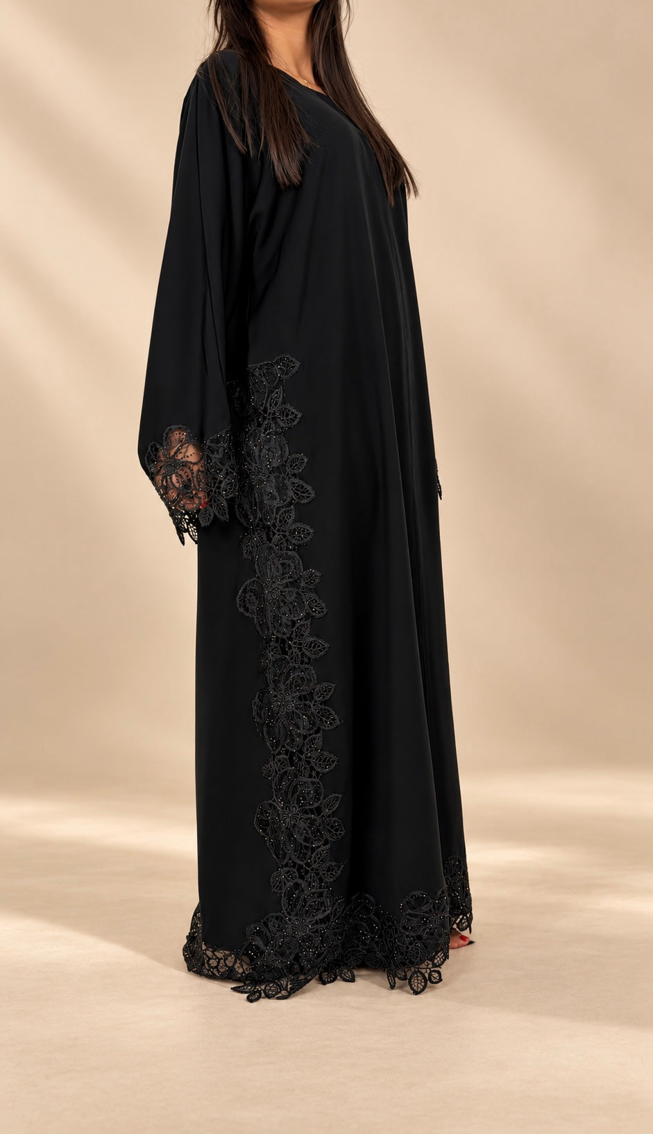 Abaya Khaimah noire de profil, guipure florale sur le panneau latéral